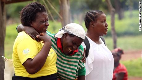 Women console a mourner as relatives arrive to await news on the return of the body of one of the miners.