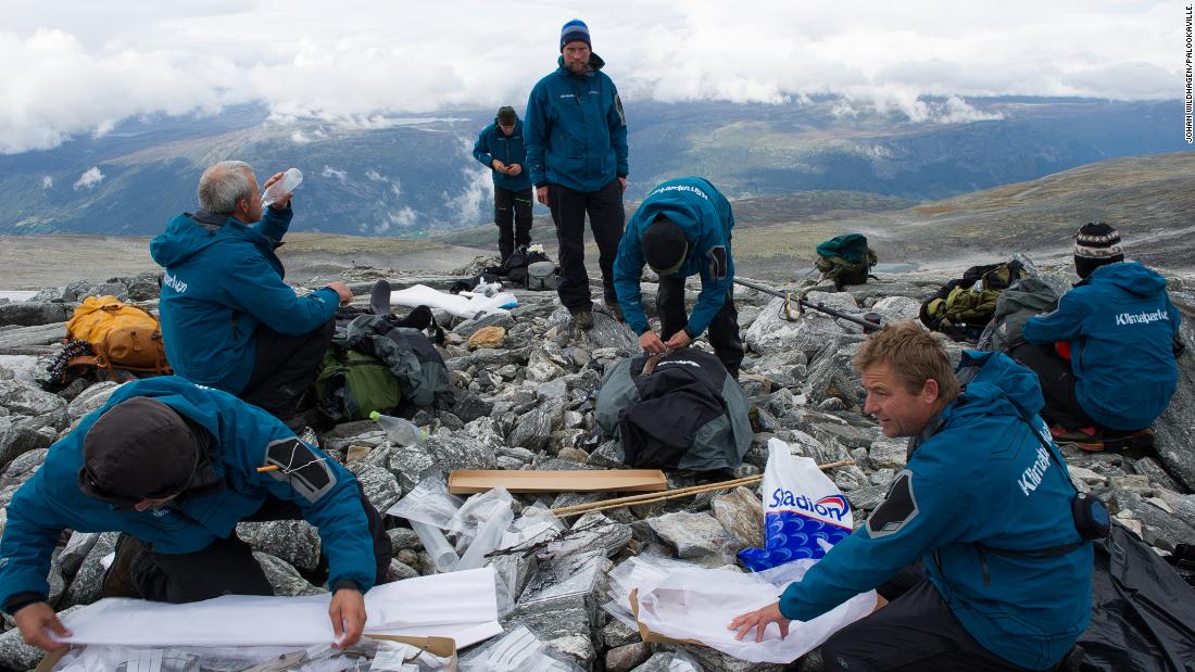 Glacial archaeologists pack artifacts after a day of fieldwork in a glaciated mountain pass.