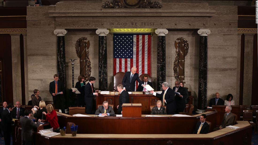 Biden hands a vote certificate to US Rep. Robert Brady as Congress officially counts the Electoral College votes in January 2013. Obama and Biden were elected to a second term in November 2012.