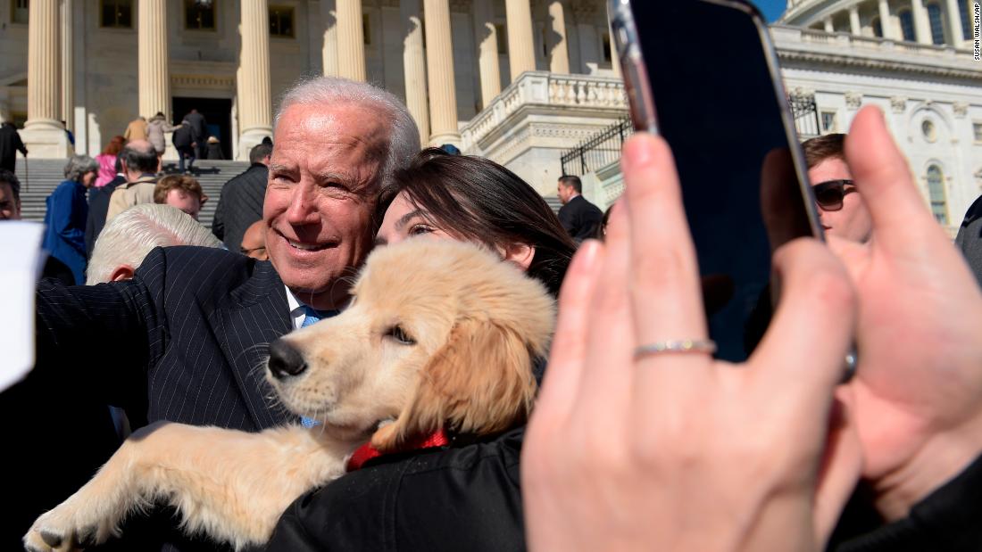 Biden poses for a photo with a dog named Biden as he greets a crowd on Capitol Hill in March 2017.