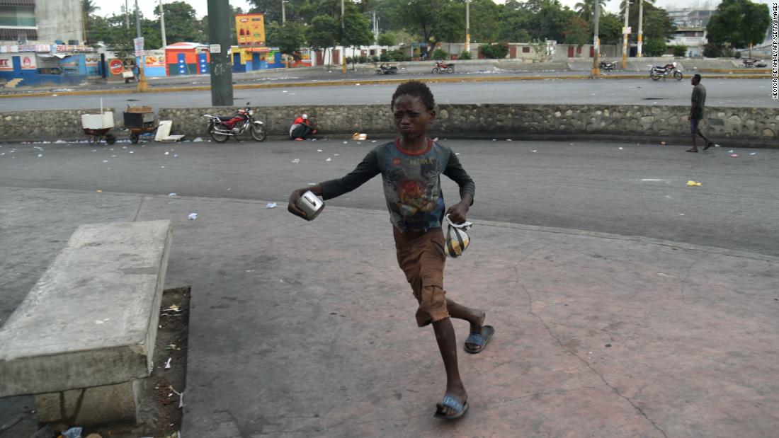 A boy flees from tear gas during clashes in Port-au-Prince on February 15.