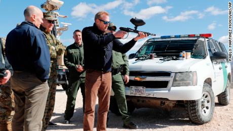 Acting Secretary of Defense Patrick Shanahan, center, fires a modified painted ball gun during a tour of the US-Mexico border at Santa Teresa Station in Sunland Park, N.M., Saturday, Feb. 23, 2019. Standing behind Shanahan is Joint Chiefs Chairman Gen. Joseph Dunford. Top defense officials toured sections of the U.S.-Mexico border Saturday to see how the military could reinforce efforts to block drug smuggling and other illegal activity, as the Pentagon weighs diverting billions of dollars for President Donald Trump's border wall.  (AP Photo/Pablo Martinez Monsivais)