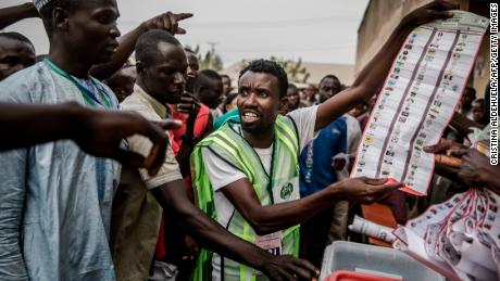 Electoral commission officers and voters talk while votes are counted at a polling station in Yola, Adamawa State, after Saturday's vote.