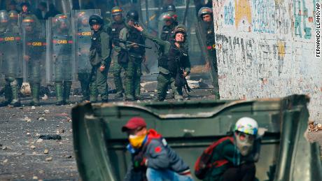 A Venezuelan Bolivarian National Guard officer throws a teargas grenade towards demonstrator in Urena Saturday.