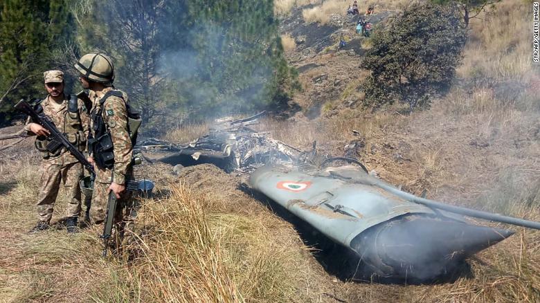 Pakistani soldiers stand next to what Pakistan said was the wreckage of a downed Indian fighter jet on February 27, 2019.
