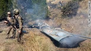 Pakistani soldiers stand next to what Pakistan said was the wreckage of a downed Indian fighter jet on February 27, 2019.