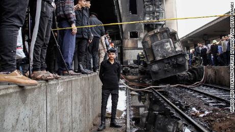 A policeman stands next to wreckage on the tracks after the accident at the Cairo train station. 