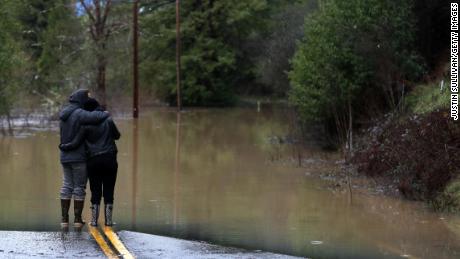 Guerneville residents Ari Herman, left, and Lea Herman look Wednesday at a flooded section of highway.