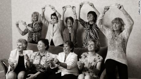 The Original Nine recreate their iconic photo from 1970 in 2012, with Julie Heldman (bottom right), who was not in the original image, replacing her mother. The women are holding one-dollar bills, which commemorate the symbolic professional contracts they signed in order to affirm their commitment to the Virginia Slims Circuit.