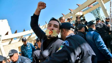 An Algerian policeman restrains a protester in a rally on February 28 organized by journalists against alleged censorship. 