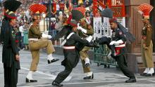 TO GO WITH AFP STORY &quot;Pakistan-vote-India-peace&quot; by Charlie McDonald-Gibson In this picture taken on February 20, 2008 at the Wagah border post with India, some 30 km from Lahore, Pakistani honour guards (black uniforms) and Indian rangers (background) take part in the daily flag-lowering ceremony.  Every evening as dusk falls on the India-Pakistan border post near Lahore, crowds gather on either side of the frontier and scream slogans at each other in a choreographed show of bravado. India on February 20 welcomed the elections in Pakistan and said it hoped to see fresh talks with its nuclear-armed South Asian rival.           AFP PHOTO/LIU Jin (Photo credit should read LIU JIN/AFP/Getty Images)