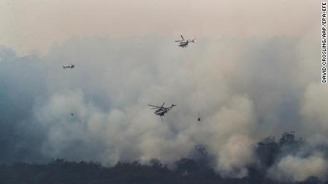 Helicopters drop water on a bushfire near Yiinnar in Gippsland, Australia, on Monday.