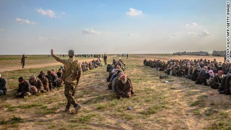 Men suspected of being ISIS fighters wait to be searched by the Kurdish-led Syrian Democratic Forces after leaving Baghouz last month.