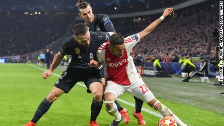 Ajax midfielder Hakim Ziyech (R) fights for the ball with Real Madrid's Spanish defender Dani Carvajal (L) and Real Madrid's Welsh forward Gareth Bale.