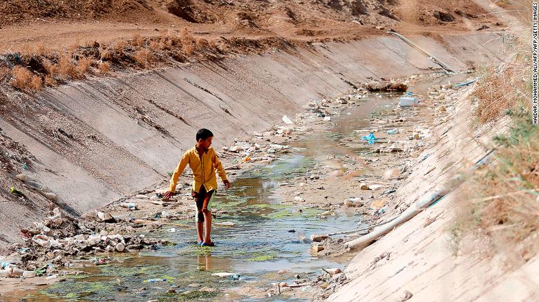 Um menino iraquiano passa por um dique de irrigação seco na aldeia de Sayyed Dakhil, cerca de 300 quilômetros ao sul de Bagdá, em 20 de março de 2018. A seca está ameaçando a agricultura e a subsistência na área.