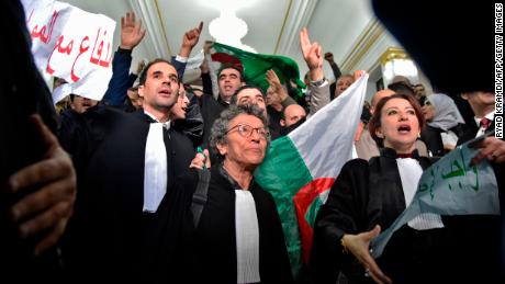 Algerian lawyers protest on February 25, holding up placards with slogans in Arabic that read: "The lawyers are with the people."