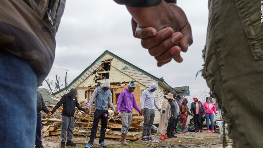 Residents of Talbotton, Georgia, pray together outside a home destroyed by a tornado.