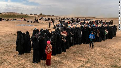 Civilians evacuated from the embattled holdout of Baghouz wait to be screened by SDF fighters.