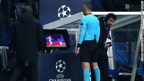 Match referee Damir Skomina checks the VAR system before awarding a penalty in favor of Manchester United.