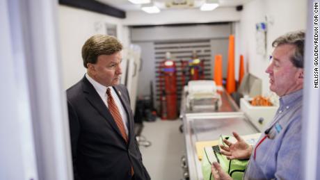 Republican Rep. Mike Rogers of Alabama, left, talks with Lee County Coroner Bill Harris in a mobile autopsy trailer in Beauregard.