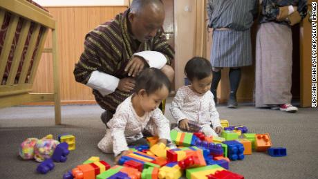 Nima and Dawa Pelden play as their father Sonam Tshering looks on.