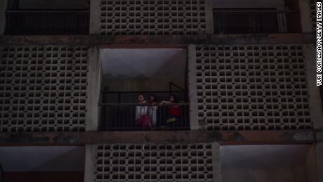 Women look from an apartment building during a power cut in Caracas.