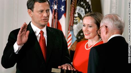 Jane Roberts (C) holds a Bible as John Roberts (L) raises his right hand as he is sworn in as Chief Justice of the United States Supreme Court by Associate Justice John Paul Stevens during a ceremony in the East Room at the White House Sept. 29, 2005, in Washington DC.