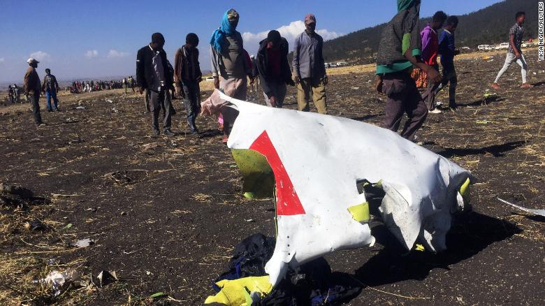 People walk past a part of the wreckage at the scene of the Ethiopian Airlines Flight ET 302 plane crash, near the town of Bishoftu, southeast of Addis Ababa, Ethiopia March 10, 2019. REUTERS/Tiksa Negeri