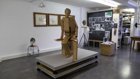 A cardboard version of the statue stands in the studio.