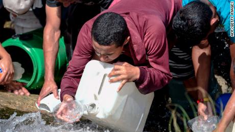 People collect water from a sewage canal at the river Guaire in Caracas on March 11, 2019, as a massive power outage continues affecting some areas of the country. - Venezuela's opposition leader Juan Guaido will ask lawmakers on Monday to declare a &quot;state of alarm&quot; over the country's devastating blackout in order to facilitate the delivery of international aid -- a chance to score points in his power struggle with President Nicolas Maduro. (Photo by JUAN BARRETO / AFP)        (Photo credit should read JUAN BARRETO/AFP/Getty Images)