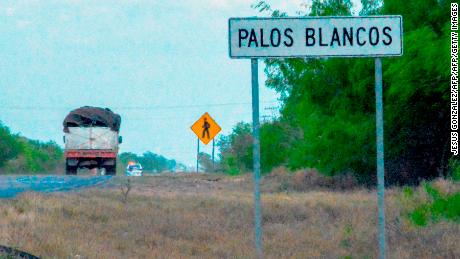 A truck drives past a sign on the Reynosa-San Fernando highway, near the location where 19 migrants went missing.