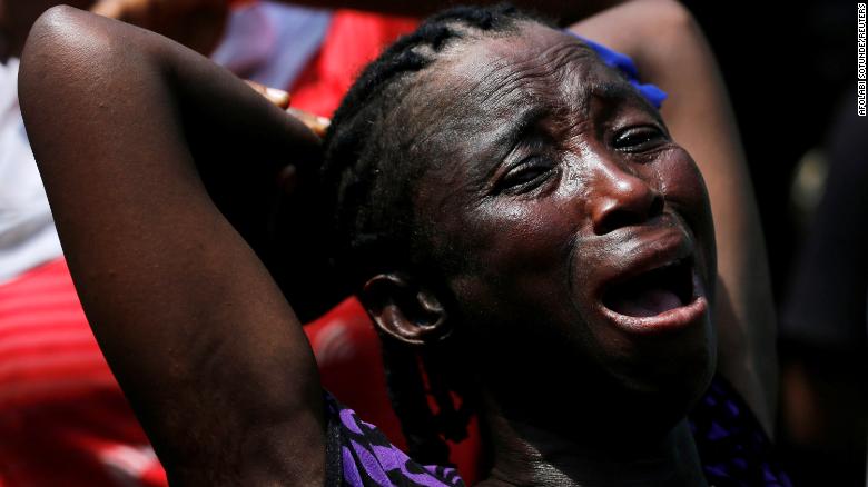 A woman cries out at the site of a collapsed building.