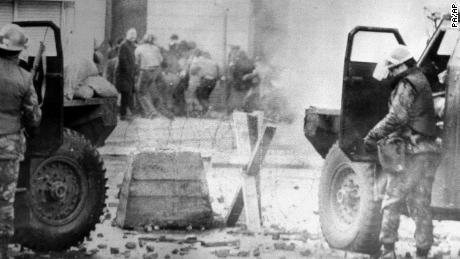 FILE - In this Jan. 30, 1972 file photo, soldiers take cover behind their sandbagged armoured cars in Londonderry, Northern Ireland. A former British soldier is set to be prosecuted in connection with the deaths of two civil rights protesters in Northern Ireland more than 40 years ago, part of an event known as Bloody Sunday. (PA via AP, File)