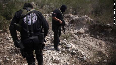 Police officers stand next to a mass grave near San Fernando, Mexico, in 2011. At the time, authorities said a drug gang was kidnapping passengers from buses and hiding their victims in hidden graves.