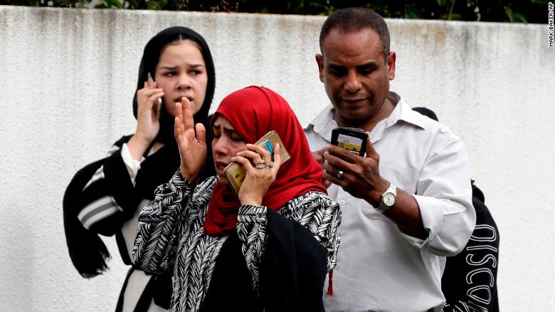 People wait outside a mosque in central Christchurch, New Zealand, on Friday.