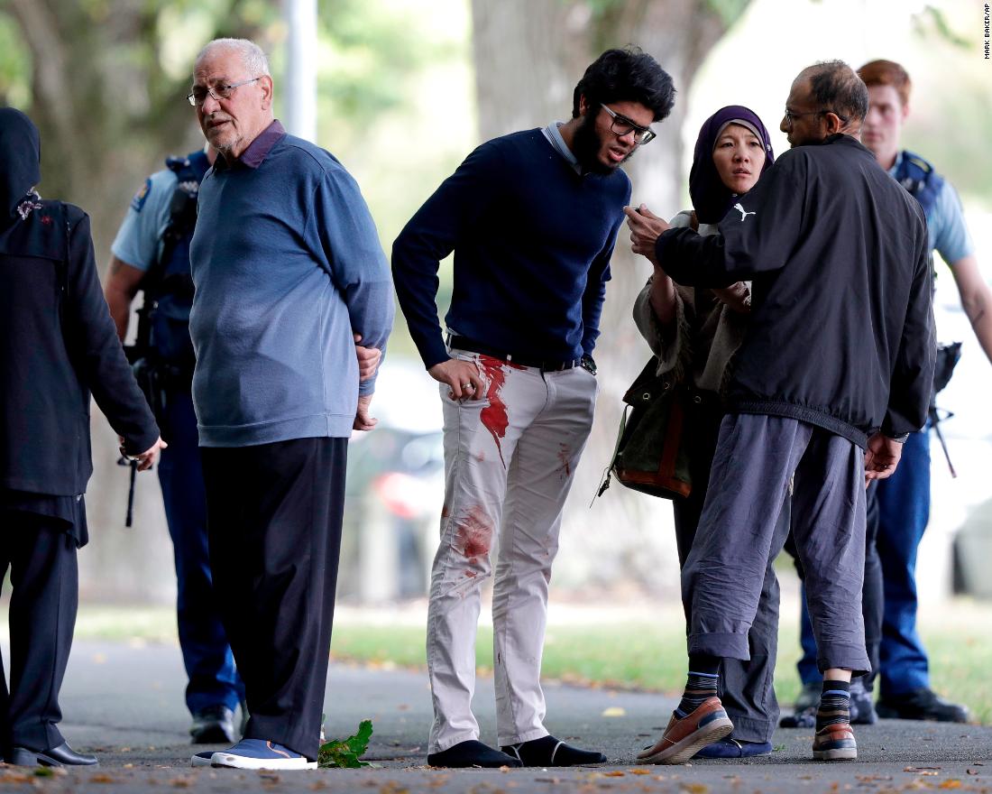 People stand across the road from one of the targeted mosques.