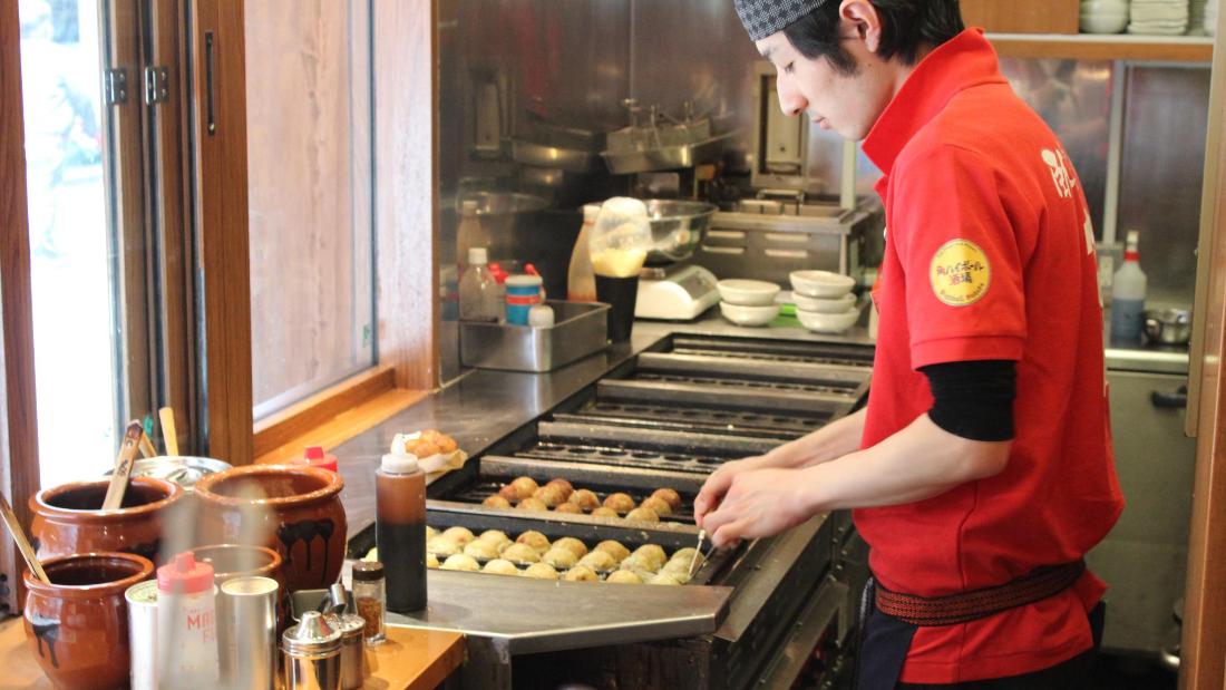 A chef in Tokyo&#39;s Akasaka district prepares takoyaki -- deep-fried octopus balls. 