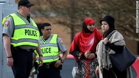 American Muslims stand outside with police officers on March 15 at the Dar Al Hijrah Islamic Center in Falls Church, Virginia.