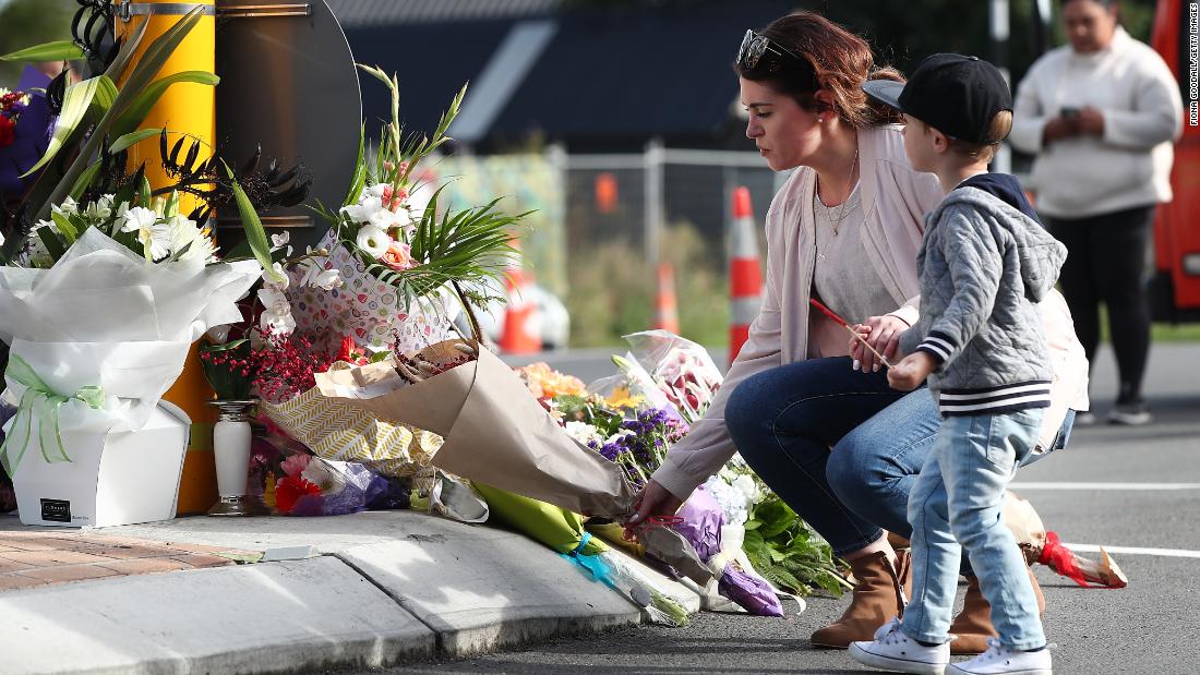 A woman lays flowers at Deans Avenue near Al Noor Mosque in Christchurch on March 16. More than 40 people were killed at that mosque, according to authorities