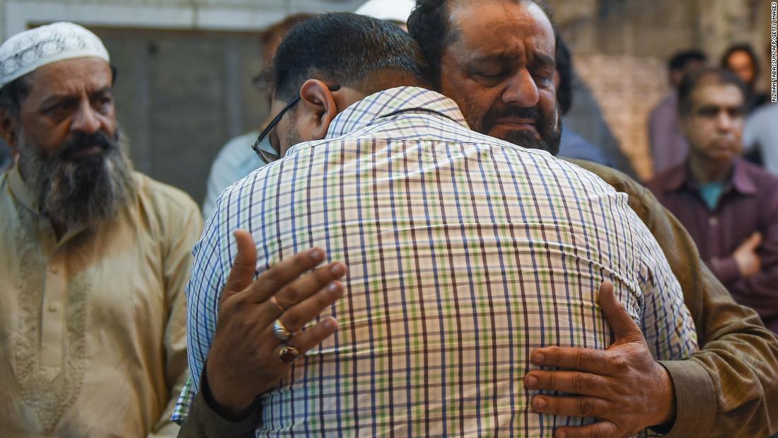 A Pakistani man embraces the father of Syed Areeb Ahmed (right), reportedly gunned down in the New Zealand massacre, in Karachi on March 16.