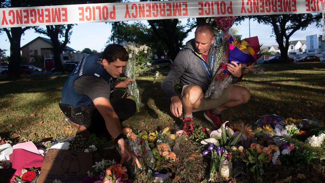 Police officers prepare to transport flowers from the cordon to the Dean Avenue mosque on Sunday, March 17, in Christchurch.