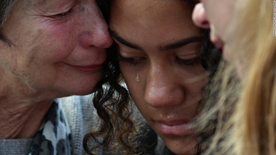 Residents cry after leaving flowers in tribute to victims in Christchurch on Sunday, March 17.