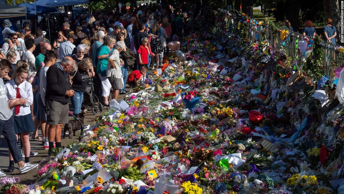 Floral tributes to those who were gunned down at the two mosques are seen against a wall bordering the Botanical Garden in Christchurch on March 19, 2019. New Zealand Prime Minister Jacinda Ardern vowed never to utter the name of the gunman as she opened a sombre session of parliament with an evocative &quot;as-salaam alaikum&quot; message of peace to Muslims.