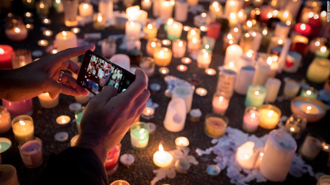 A mourner takes a picture of candles commemorating victims of Friday&#39;s shooting, outside the Al Noor mosque in Christchurch, New Zealand, Monday, March 18. Three days after the attack, New Zealand&#39;s deadliest shooting in modern history, relatives were anxiously waiting for word on when they can bury their loved ones.