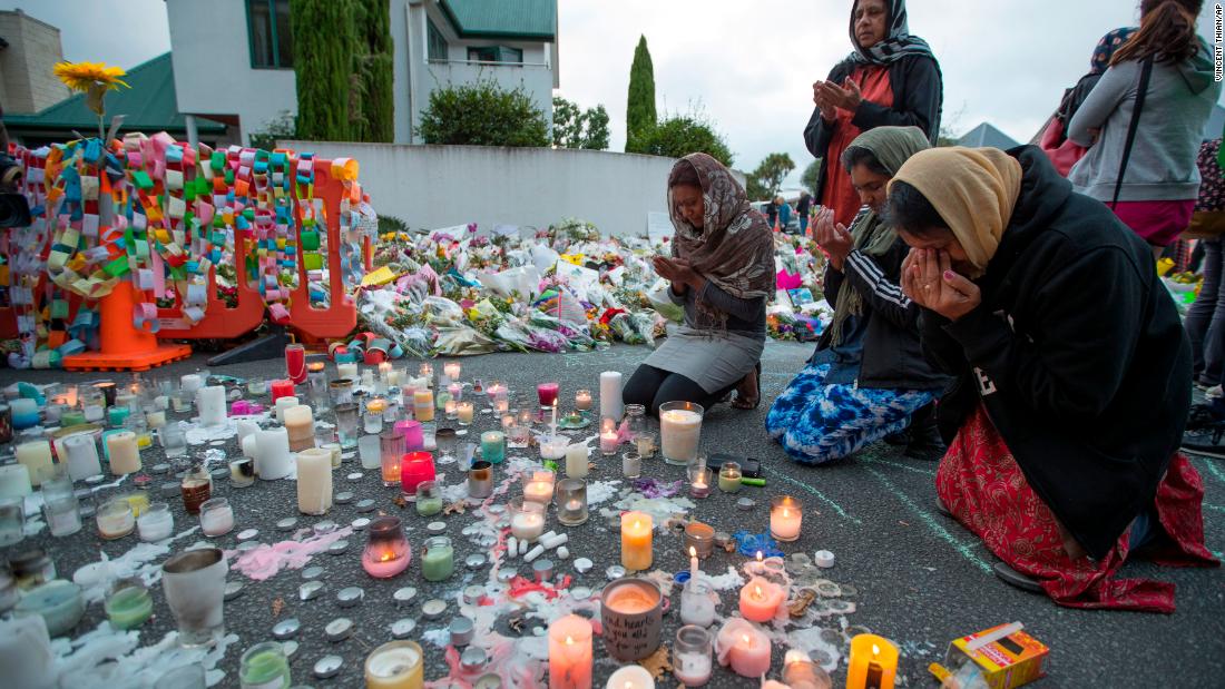 People mourn at a makeshift memorial site near the Al Noor mosque in Christchurch, New Zealand, on Tuesday, March 19. Streets near the hospital that had been closed for four days reopened to traffic as relatives and friends of the victims of last week&#39;s mass shootings continued to stream in from around the world.