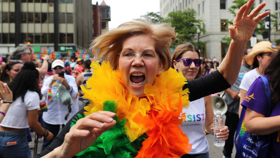 Warren runs down Boston&#39;s Clarendon Street waving to crowds during the annual Boston Pride Parade in June 2018.