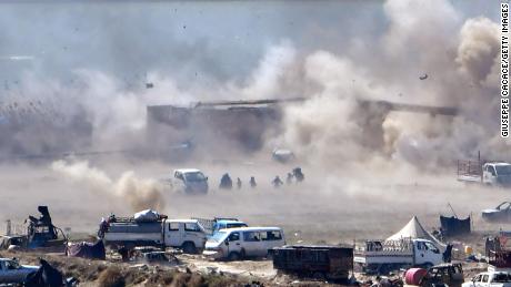 TOPSHOT - People are seen fleeing as heavy smoke rises above the Islamic State (IS) group's last remaining position in the village of Baghouz during battles with the Syrian Democratic Forces (SDF), in the countryside of the eastern Syrian province of Deir Ezzor on March 18, 2019. - A shroud of black smoke covered the Islamic State group's last Syria redoubt today as US-backed forces battled holdout jihadists after a night of shelling and heavy air strikes. The Kurdish-led SDF have been closing in on IS fighters holed up in a small sliver of territory in the village of Baghouz in eastern Syria since January. (Photo by GIUSEPPE CACACE / AFP)        (Photo credit should read GIUSEPPE CACACE/AFP/Getty Images)