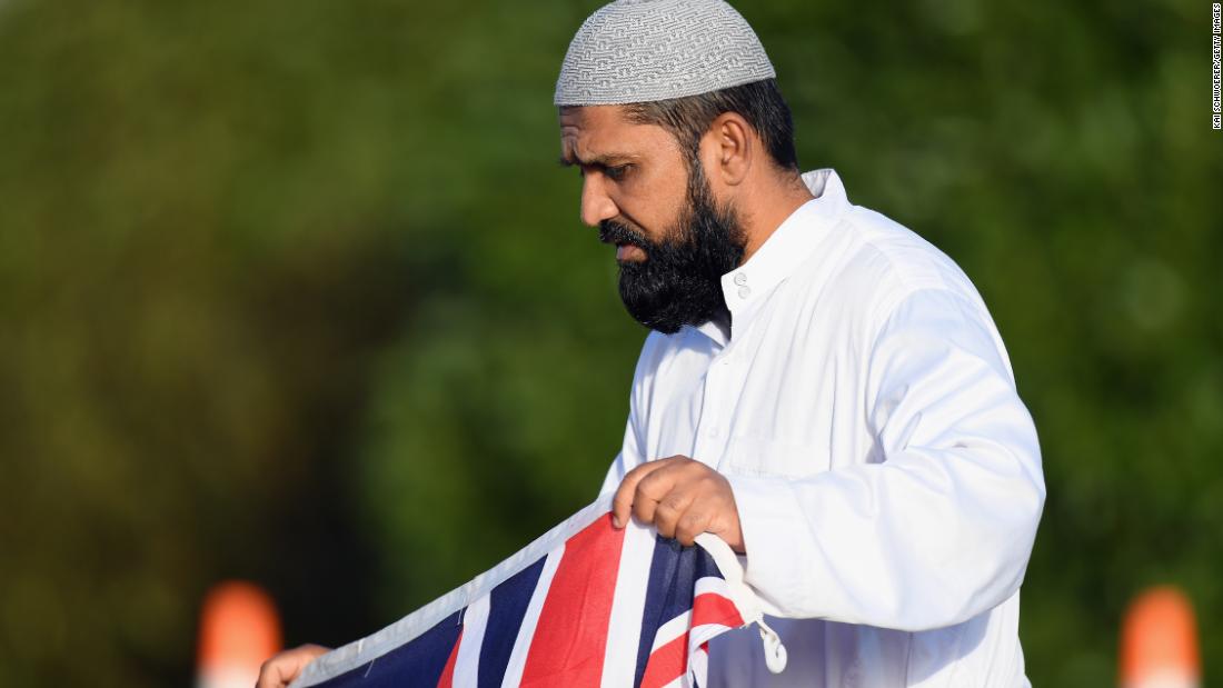  A mourner holds a New Zealand flag during a mass burial at Memorial Park Cemetery in Christchurch on March 22.