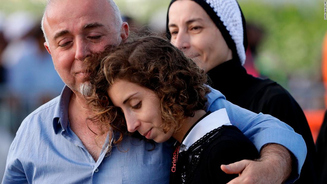 Mourners embrace following a burial ceremony at Memorial Park Cemetery in Christchurch on March 22.