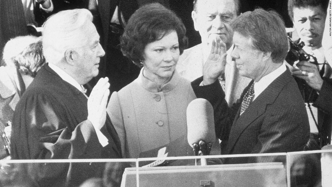 Chief Justice Warren Burger swears Carter into office on January 20, 1977, while Rosalynn Carter looks on.